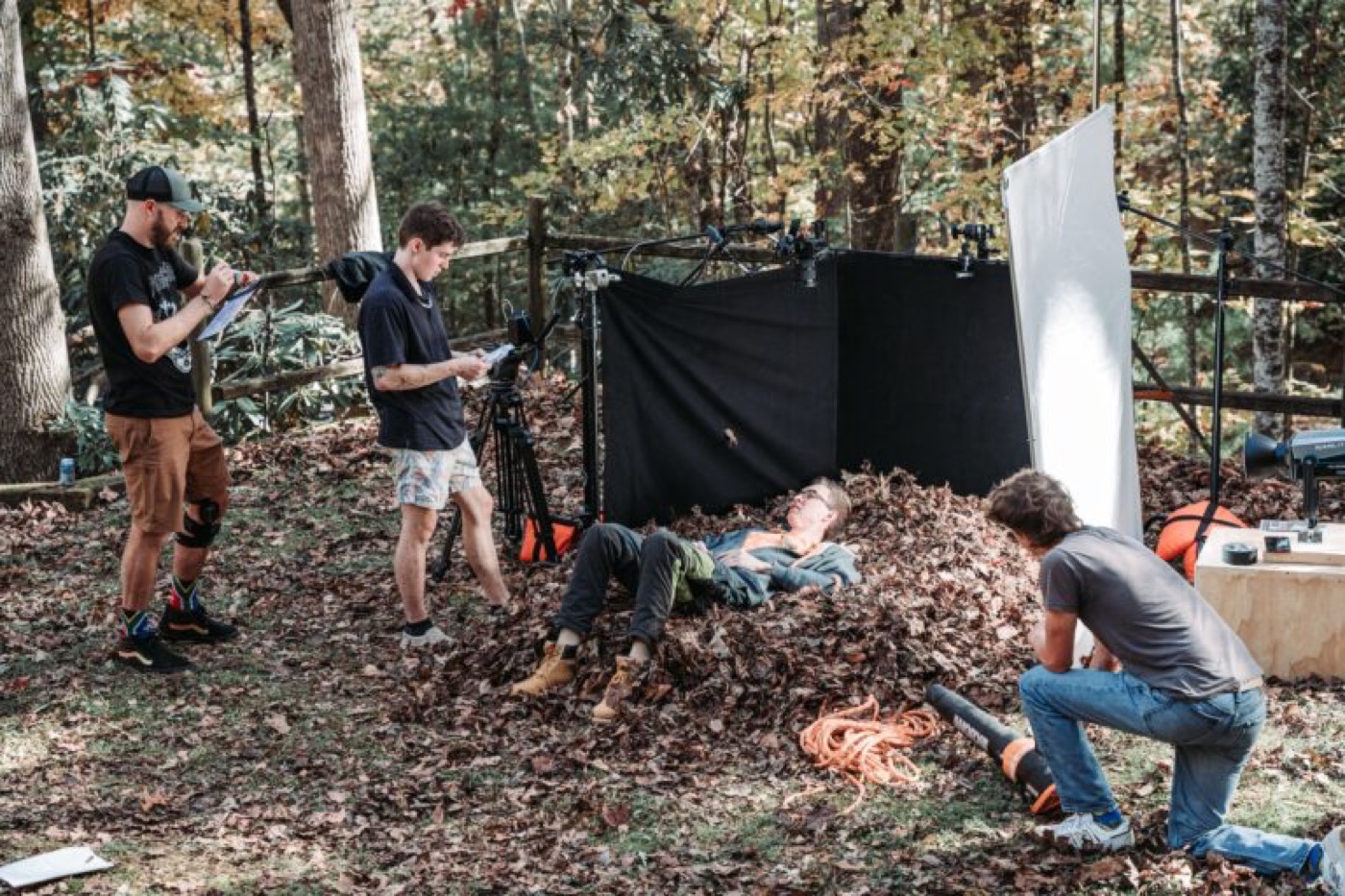 Crew setting up a scene in a pile of leaves in the woods