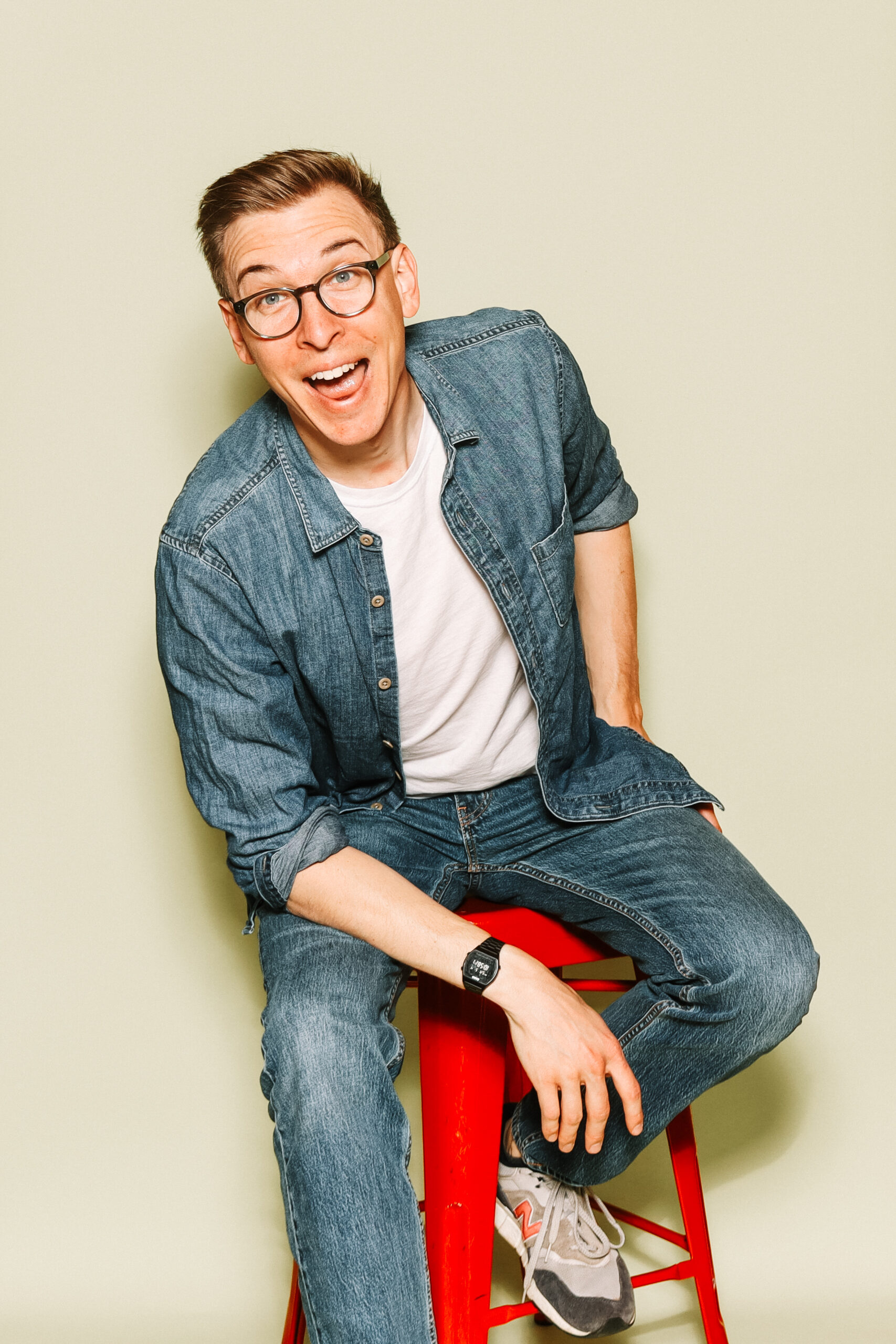 Ian Hoyt, seated on a red stool, laughing